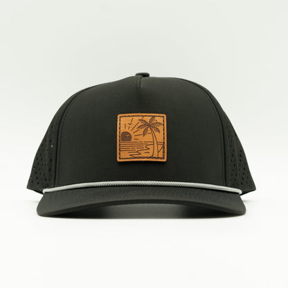 Front view of the Seaside Serenity Leather Patch Hat by Outer Wings in black, showcasing the rope detail, water-resistant fabric, and adjustable snapback closure. A rugged and stylish outdoors hat for all your adventures.