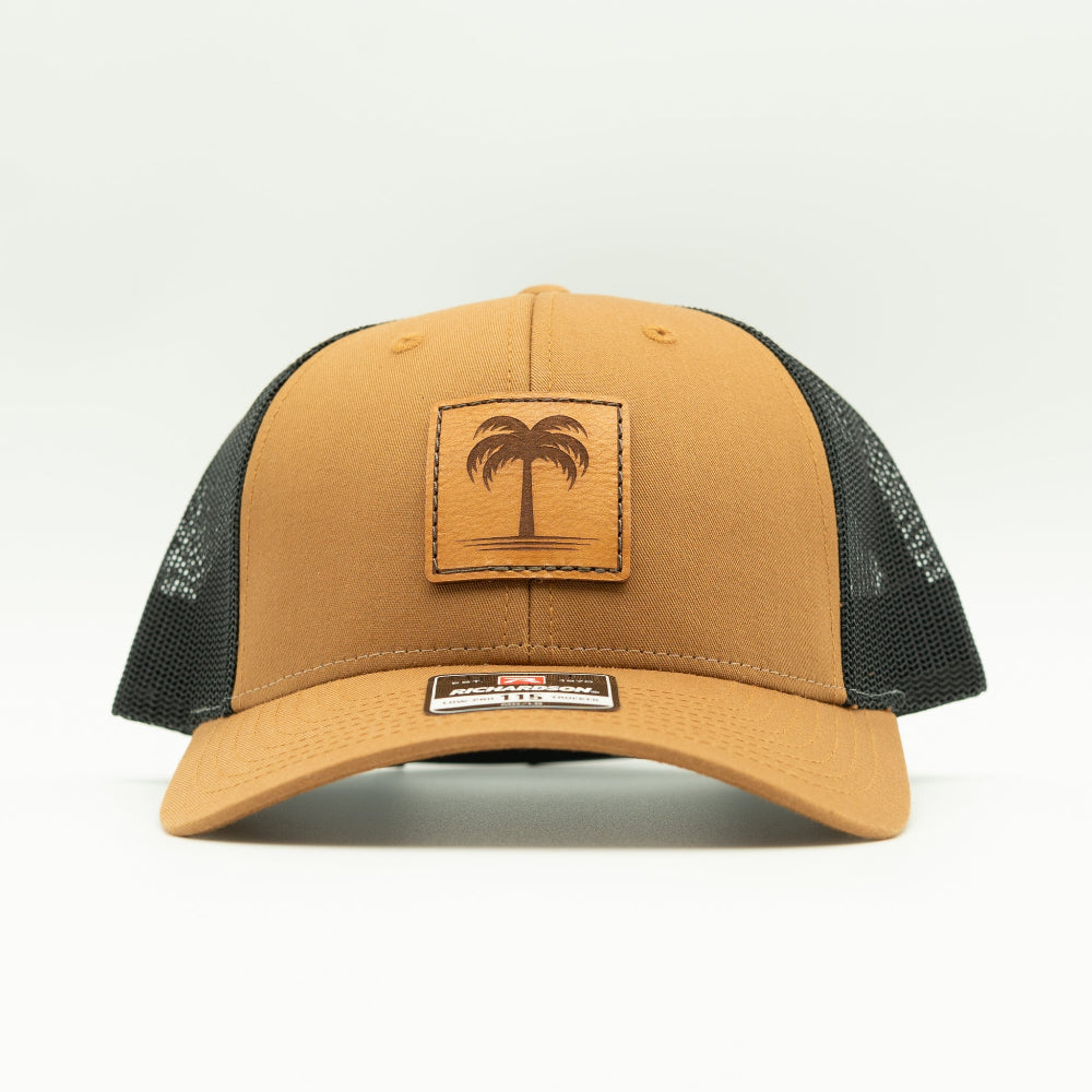 Front view of the Solo Palm Leather Patch Hat by Outer Wings in Caramel/Black, highlighting the structured profile, breathable mesh back, and adjustable SnapBack closure. A stylish and durable custom leather patch hat for casual and outdoor wear.