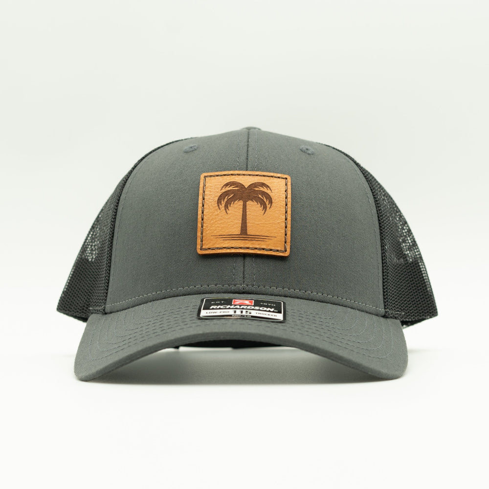 Front view of the Solo Palm Leather Patch Hat by Outer Wings in Charcoal/Black, showcasing the breathable mesh back, structured profile, and adjustable SnapBack closure. A stylish and durable outdoors hat for all adventures.