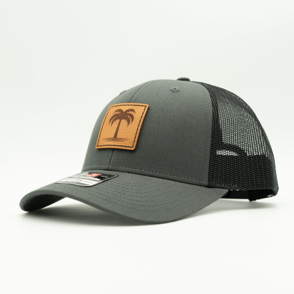 Side view of the Solo Palm Leather Patch Hat by Outer Wings in Charcoal/Black, showcasing the breathable mesh back, structured profile, and adjustable SnapBack closure. A stylish and durable outdoors hat for all adventures.