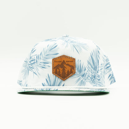 Front view of the Summit Seeker Leather Patch Hat by Outer Wings in White Pine, highlighting the breathable fabric, white rope accent, and adjustable leather strap. A stylish and functional custom leather patch hat for all outdoor adventures.