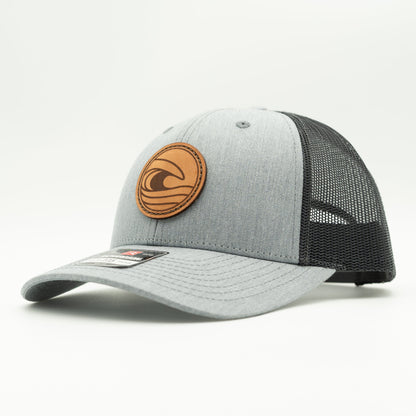 Side view of the Tidal Wave Leather Patch Hat by Outer Wings in Heather Grey/Charcoal, highlighting the structured design, mesh back, and adjustable SnapBack closure. A rugged yet stylish outdoors hat for all your adventures.