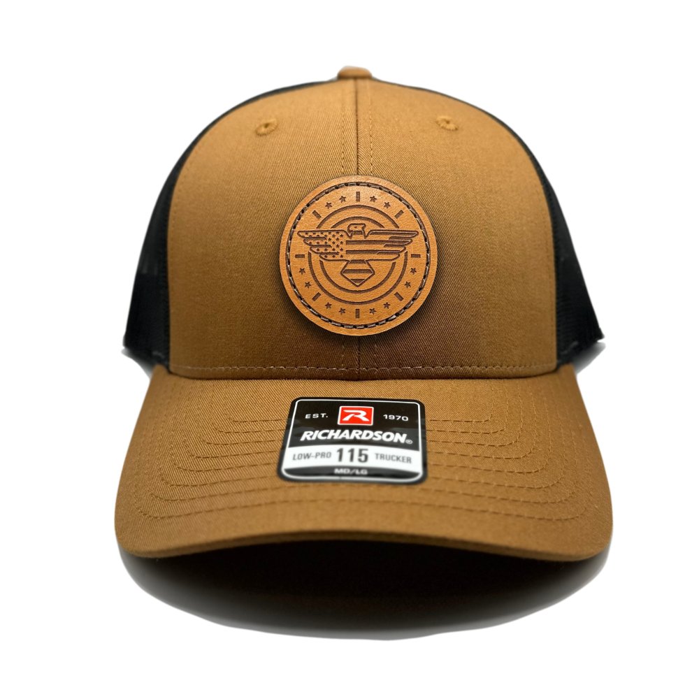 Front view of the American Eagle Design leather patch hat by Outer Wings in caramel/black, featuring a low-profile Richardson 115 hat with an intricate leather patch of an eagle, American flag, stars, and stripes. The caramel front with a black mesh back provides a unique and stylish contrast.