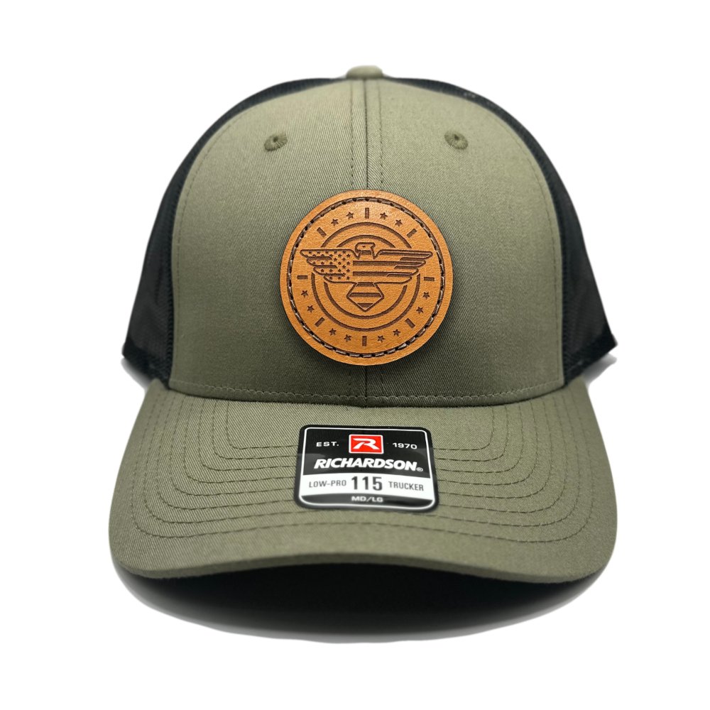 Front view of the American Eagle Design leather patch hat by Outer Wings in loden/black, featuring a low-profile Richardson 115 hat with a distinctive leather patch of an eagle, American flag, stars, and stripes. The loden green front paired with a black mesh back provides a rugged, outdoor-inspired look.