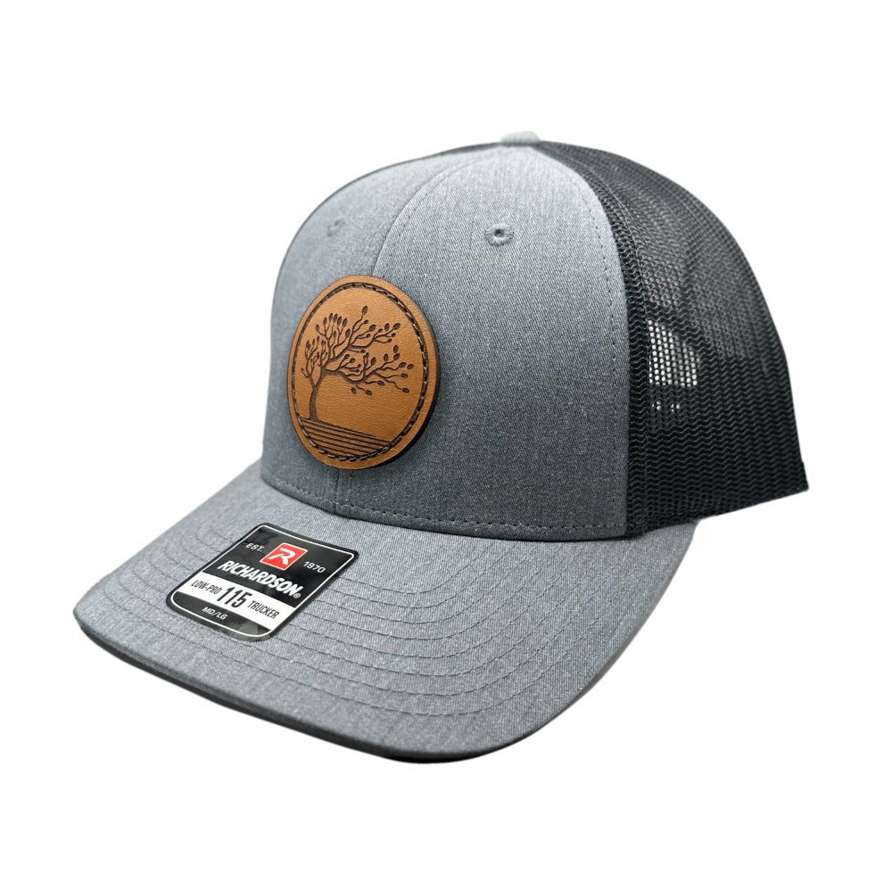 Side view of the Blossom Leather Patch Hat by Outer Wings in heather grey/dark charcoal, highlighting the hat’s low-profile design, comfortable fit, and adjustable SnapBack. The Blossom leather patch adds a unique, elegant touch to this versatile hat.