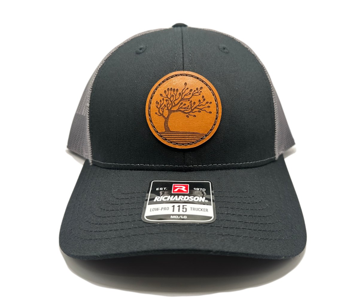 Front view of the Blossom Leather Patch Hat by Outer Wings in black/charcoal, featuring a low-profile Richardson 115 hat with a detailed leather patch of the Blossom design. The contrast of black and charcoal adds a modern touch to this versatile, outdoor-ready hat.