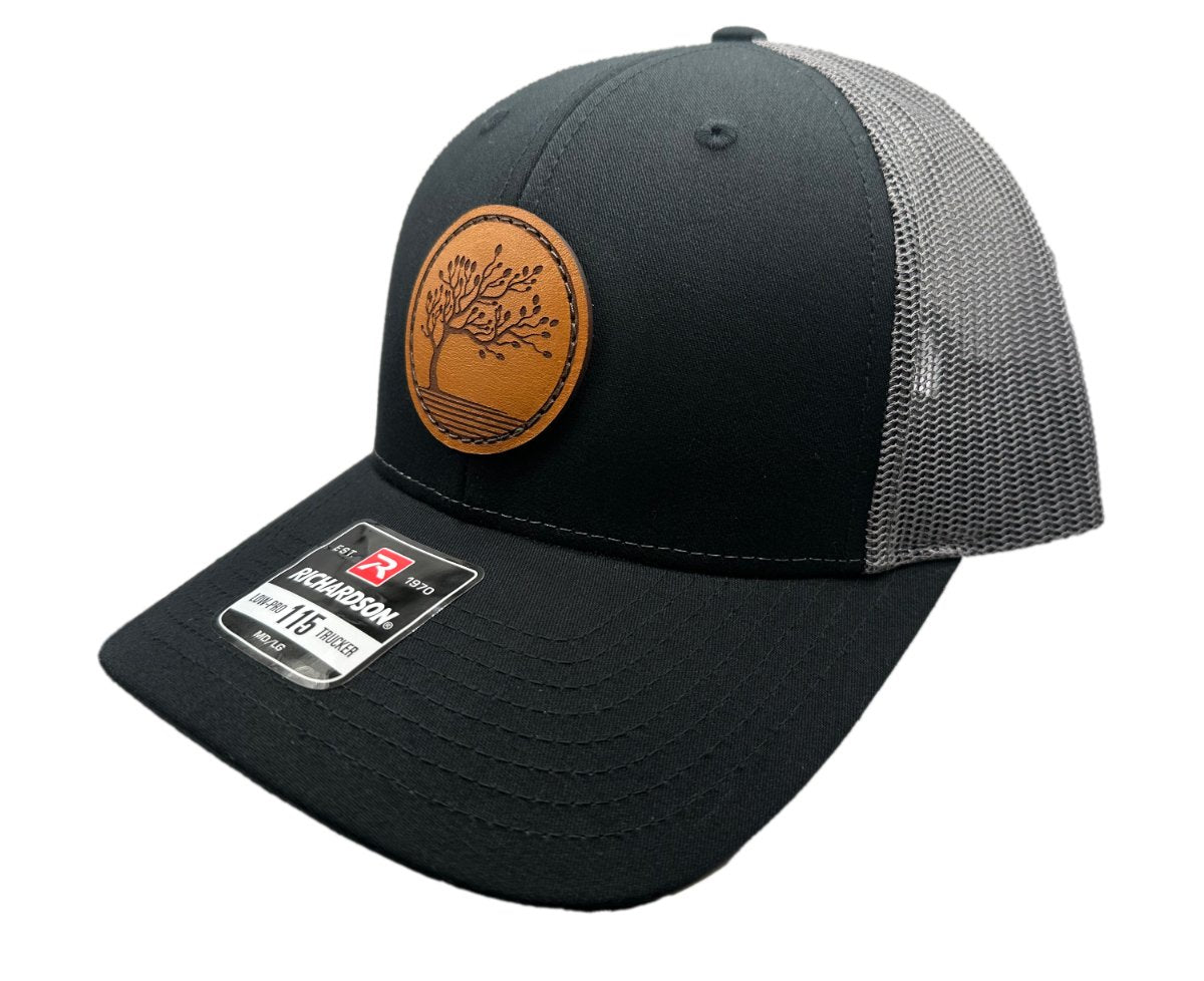 Side view of the Blossom Leather Patch Hat by Outer Wings in black/charcoal, showing the hat’s sleek, low-profile fit and adjustable SnapBack closure. The Blossom leather patch is meticulously sewn on, emphasizing quality craftsmanship.