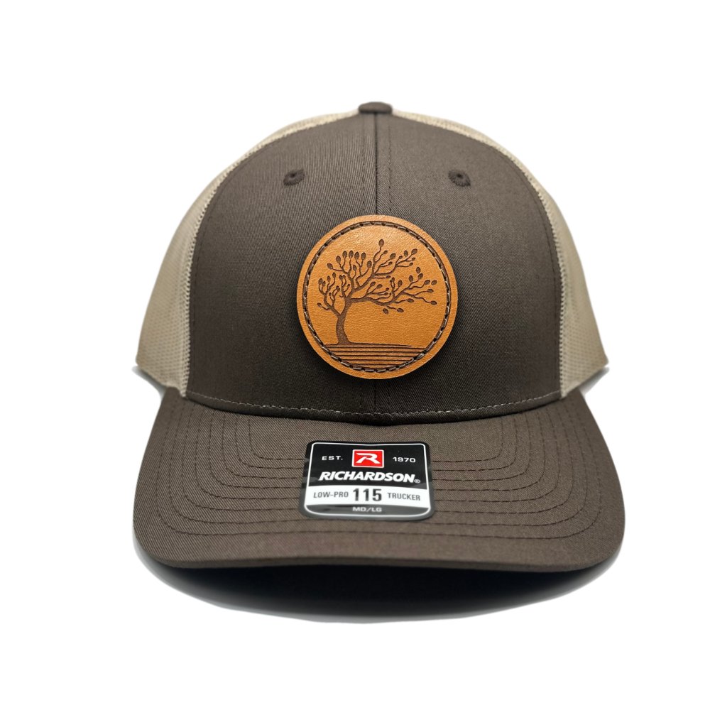 Front view of the Blossom Leather Patch Hat by Outer Wings in brown/khaki, featuring a low-profile Richardson 115 hat with a leather patch showcasing the Blossom design. The warm brown front and khaki mesh add an earthy, casual style to this comfortable hat.