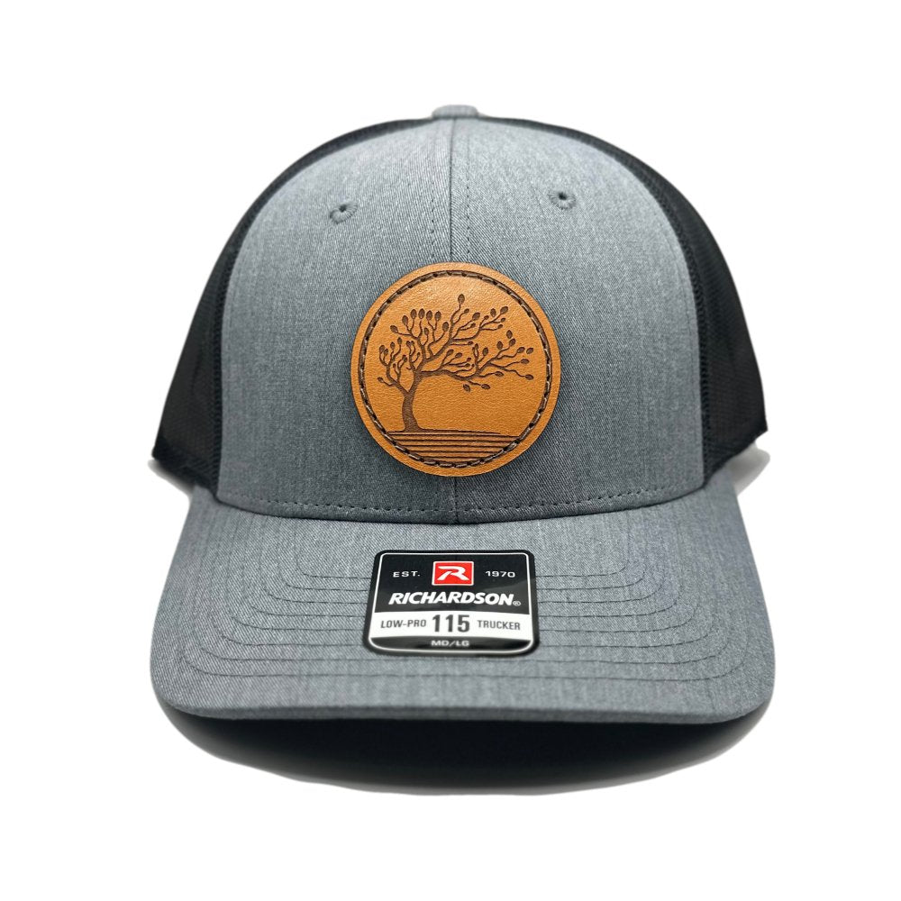 Front view of the Blossom Leather Patch Hat by Outer Wings in heather grey/dark charcoal, featuring a low-profile Richardson 115 hat with an intricate leather patch of the Blossom design. The heather grey front and dark charcoal back create a sleek and sophisticated look.