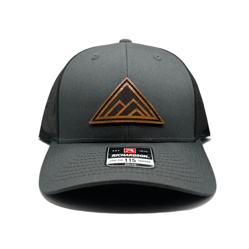 Front view of the Dark Mountain Leather Patch Hat by Outer Wings in charcoal/black on the low-profile Richardson 115. This hat features a laser-engraved Dark Mountain leather patch, expertly sewn on for a refined and durable finish, with a structured, adjustable fit.