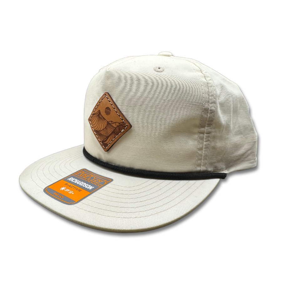 Side view of the Desert Mountain Leather Patch Hat by Outer Wings in birch/black on the Richardson 256, highlighting the low-profile fit, soft-structured build, and the distinctive Desert Mountain leather patch. The hat includes breathable mesh support and an adjustable SnapBack for all-day comfort.