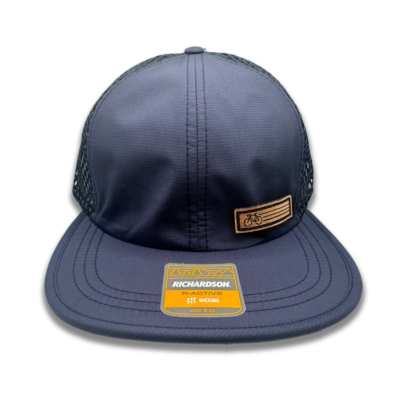 Navy Fast Bike Hat by Richardson 935 with a genuine leather Fast Bike patch, laser-engraved and hand-sewn, on a navy-colored polyester trucker hat.