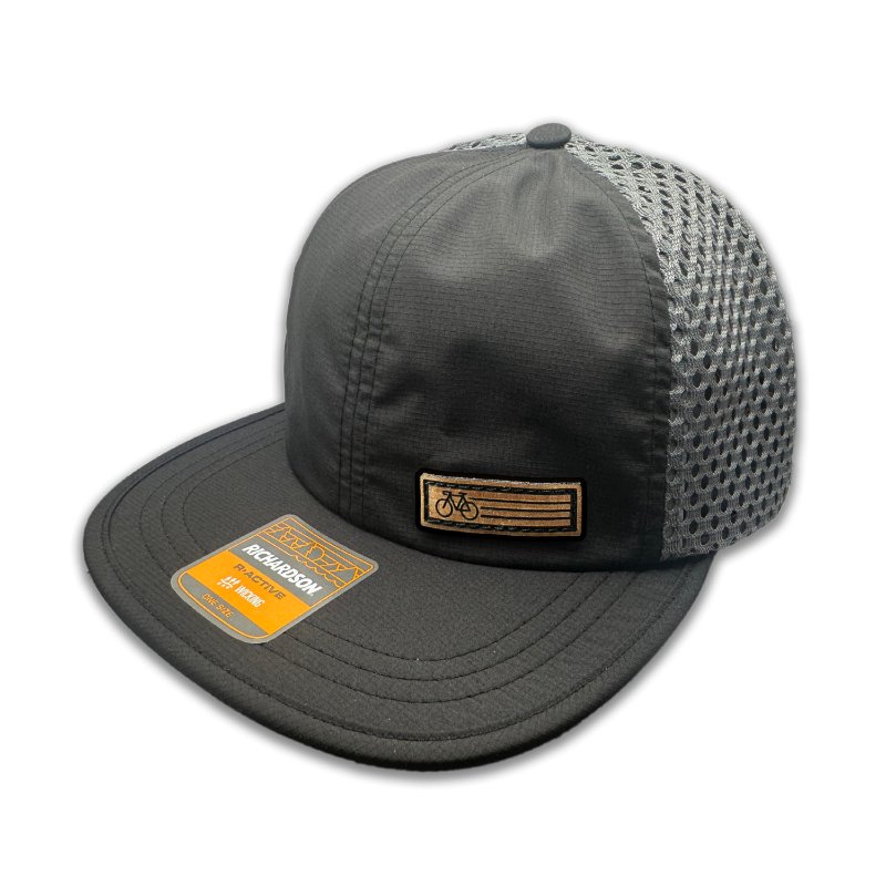 Side view of the Black Fast Bike Hat, featuring the charcoal accents and wide-set mesh back, with the Fast Bike leather patch visible from the side.