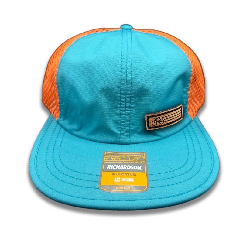 Teal Fast Bike Hat by Richardson 935 featuring the genuine leather Fast Bike patch, laser-engraved and hand-sewn, on a teal-colored polyester trucker hat with orange accents.