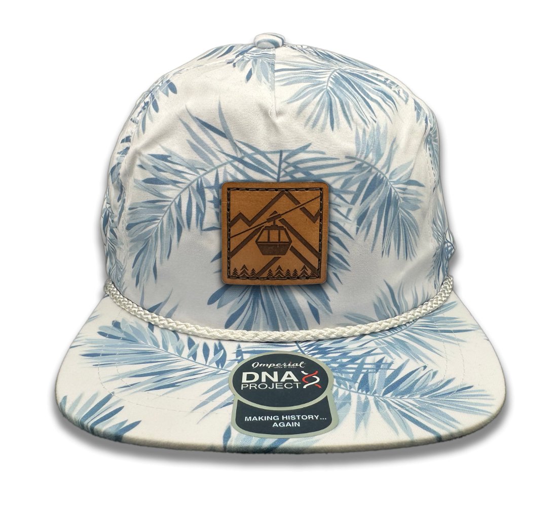 Front view of the Gondola Hat in White Pine by Outer Wings, featuring a hand-sewn genuine leather patch with winter-themed designs like skiers and ski lifts. Built on an Imperial Umpqua rope hat, it includes a structured five-panel design, mid-profile, and a moisture-wicking sweatband.