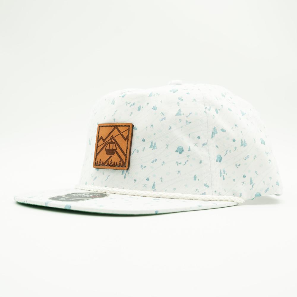 A white snapback cap with a light blue speckled pattern, featuring a brown leather patch on the front with a ski lift graphic Gondola.

Color: Blue Mountain