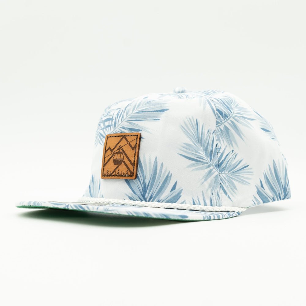 Side view of the Gondola Hat in White Pine, showing the hat’s structured profile, classic rope detail, and adjustable leather strap. The hand-sewn leather patch captures the essence of winter with intricate snow-themed designs.

Color: Floral Mist