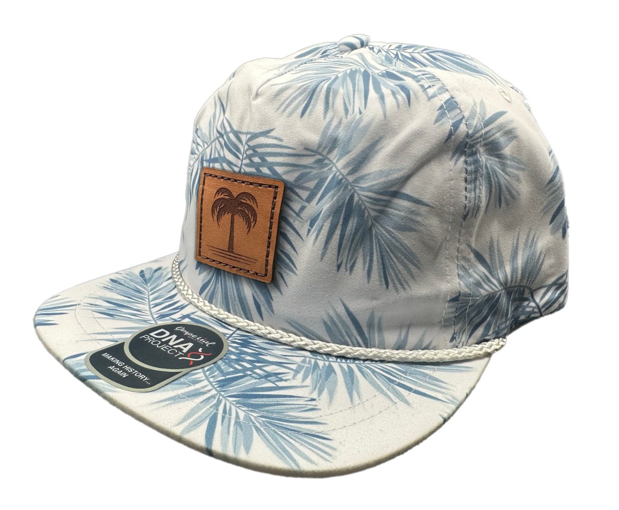 Side view of the Island Breeze Hat in Floral Mist, highlighting the floral print, structured profile, and adjustable leather strap. The hat is finished with a hand-sewn full-grain leather patch, adding a touch of tropical elegance to any outfit.