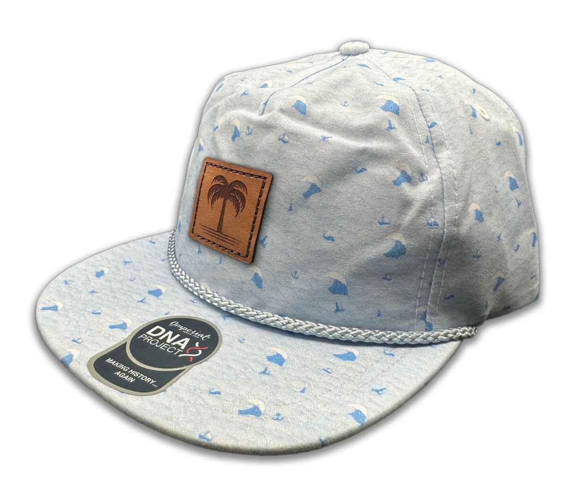 Side view of the Island Breeze Hat in Blue Waves, showcasing the ocean-inspired wave print, structured design, and classic rope detail. The hat includes a genuine leather patch with a palm tree engraving, perfect for adding a touch of island style.