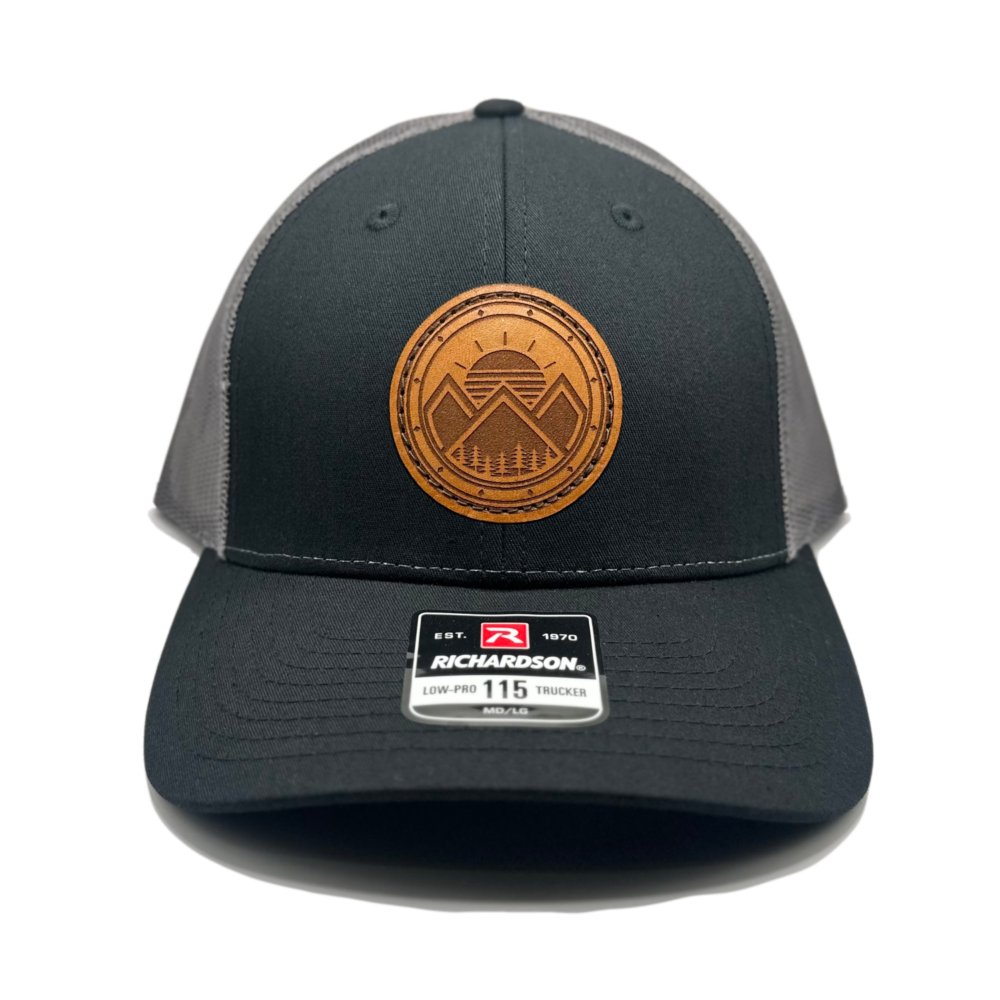 Front view of the Modern Mountains Leather Patch Hat in Black/Charcoal by Outer Wings, featuring a laser-engraved leather patch with modern mountains and sunset design. Crafted on the Richardson 115 Low Profile Hat, this hat combines comfort with a structured six-panel, low-profile fit and adjustable SnapBack.