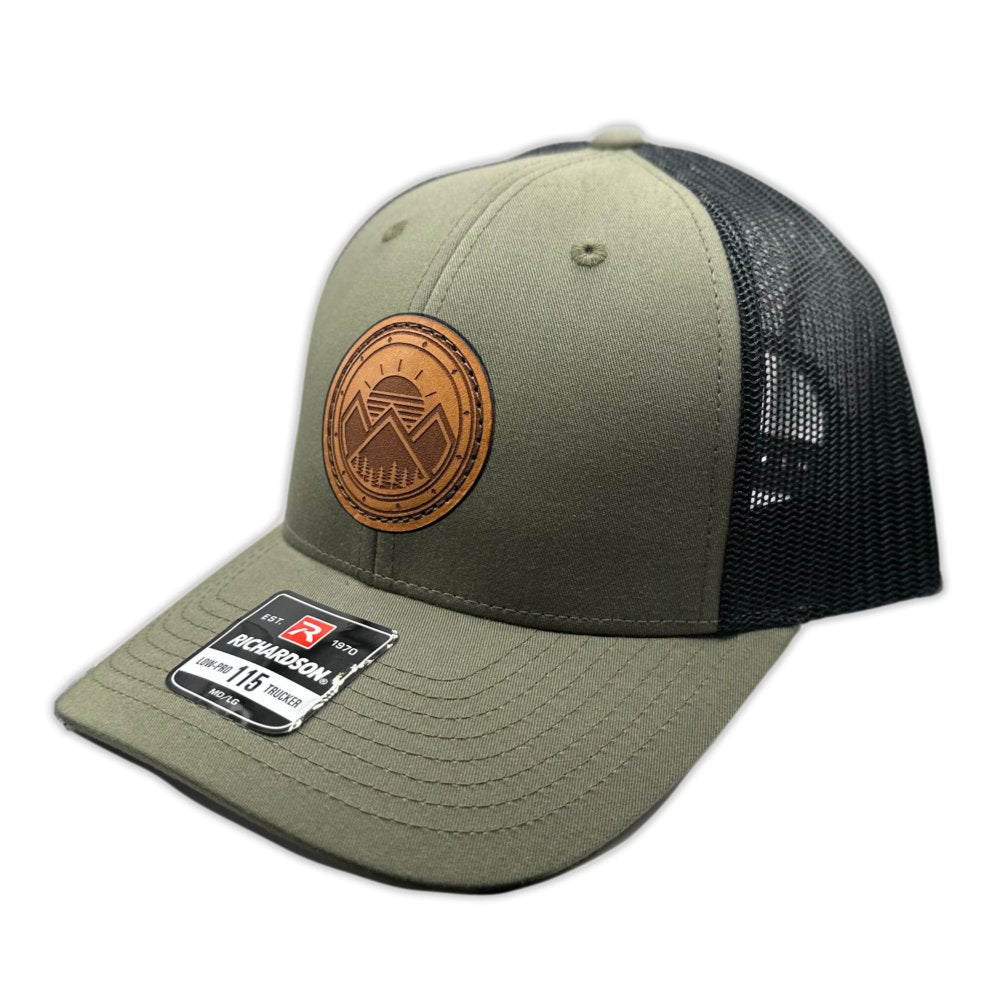 Side view of the Modern Mountains Leather Patch Hat in Loden/Black, showing the hat’s low-profile structure, pre-curved visor, and adjustable SnapBack. The leather patch features a modern mountains and sunset design, perfect for those who love the outdoors.