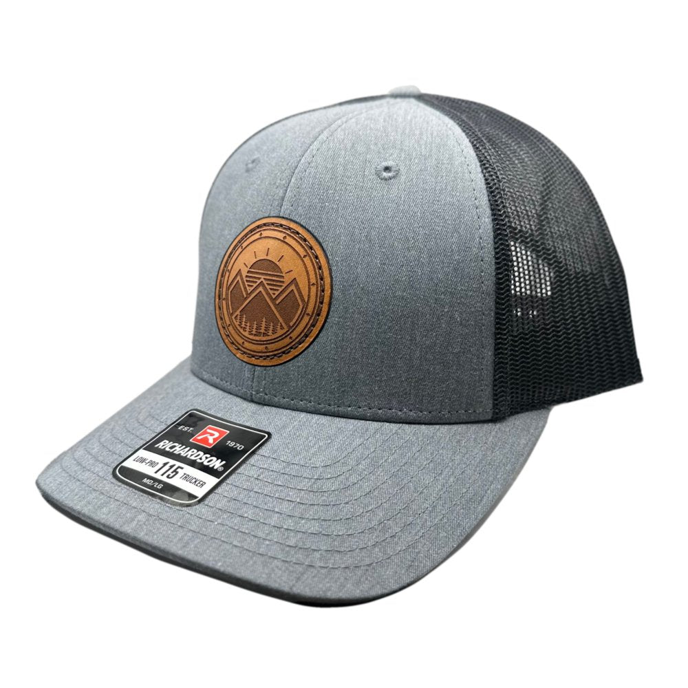 Side view of the Modern Mountains Leather Patch Hat in Heather Grey/Dark Charcoal, showcasing the breathable mesh back, structured design, and adjustable SnapBack closure. The leather patch with a modern mountains and sunset design is laser engraved for a unique, stylish look