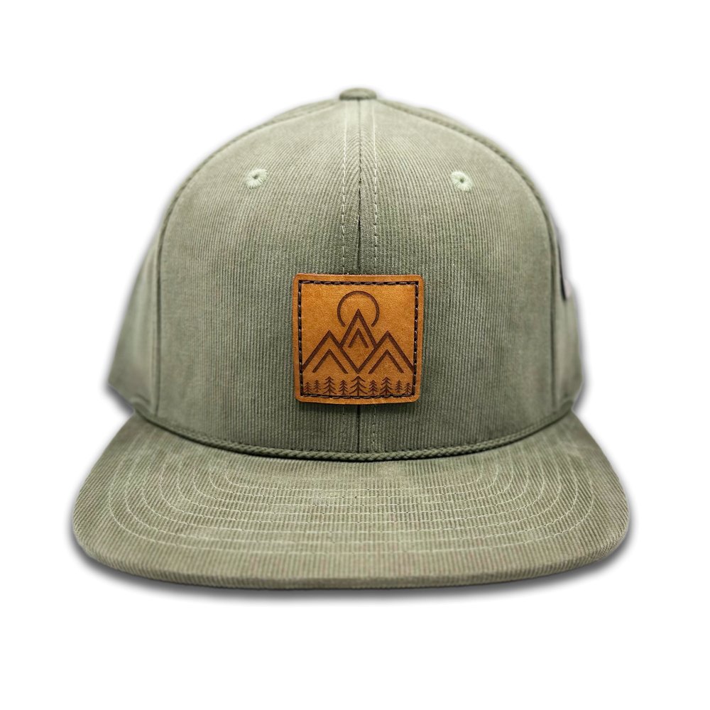 Front view of the Moonlite Mountain Hat in olive by Outer Wings, featuring a square leather patch with a laser-engraved design of modern mountains, pine trees, and a moon. Crafted on the Richardson 253 with 100% cotton corduroy, this high-profile, six-panel hat includes a flat bill and an adjustable snapback closure for a comfortable fit.