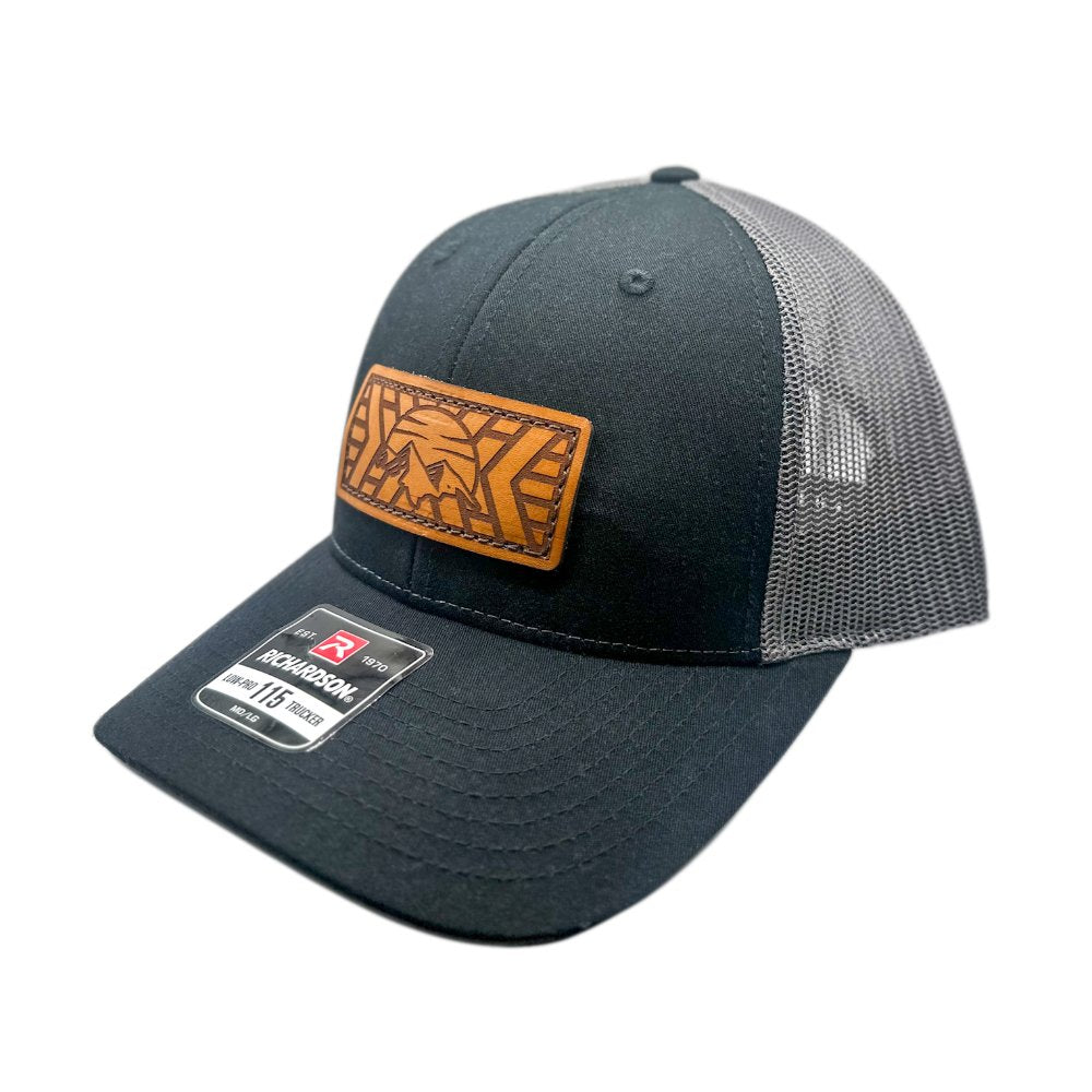 Side view of the Mosaic Mountain Leather Patch Hat by Outer Wings in black/charcoal, showcasing the low profile design of the Richardson 115. This custom leather patch hat features a detailed mountain and sunset design, hand-sewn on for added durability, making it an ideal choice for outdoor enthusiasts.