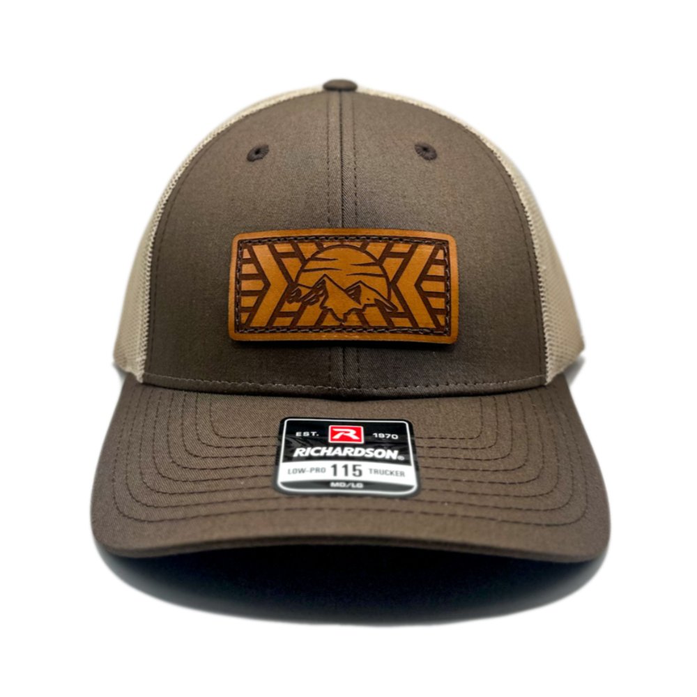 Front view of the Mosaic Mountain Leather Patch Hat by Outer Wings in brown/khaki, crafted on a low profile Richardson 115 hat. This hat features a square leather patch with a laser-engraved mountain and sunset design, making it a standout outdoors hat that blends style and functionality. The adjustable SnapBack closure offers a perfect fit.