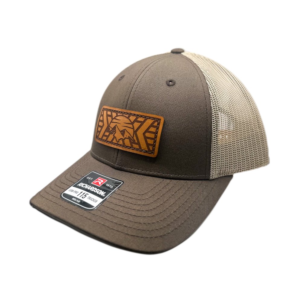 Side view of the Mosaic Mountain Leather Patch Hat by Outer Wings in brown/khaki, showcasing the structured low profile design of the Richardson 115. The hat’s leather patch features a detailed mountain and sunset engraving, sewn onto the hat for a rugged, stylish look, perfect for outdoor enthusiasts.