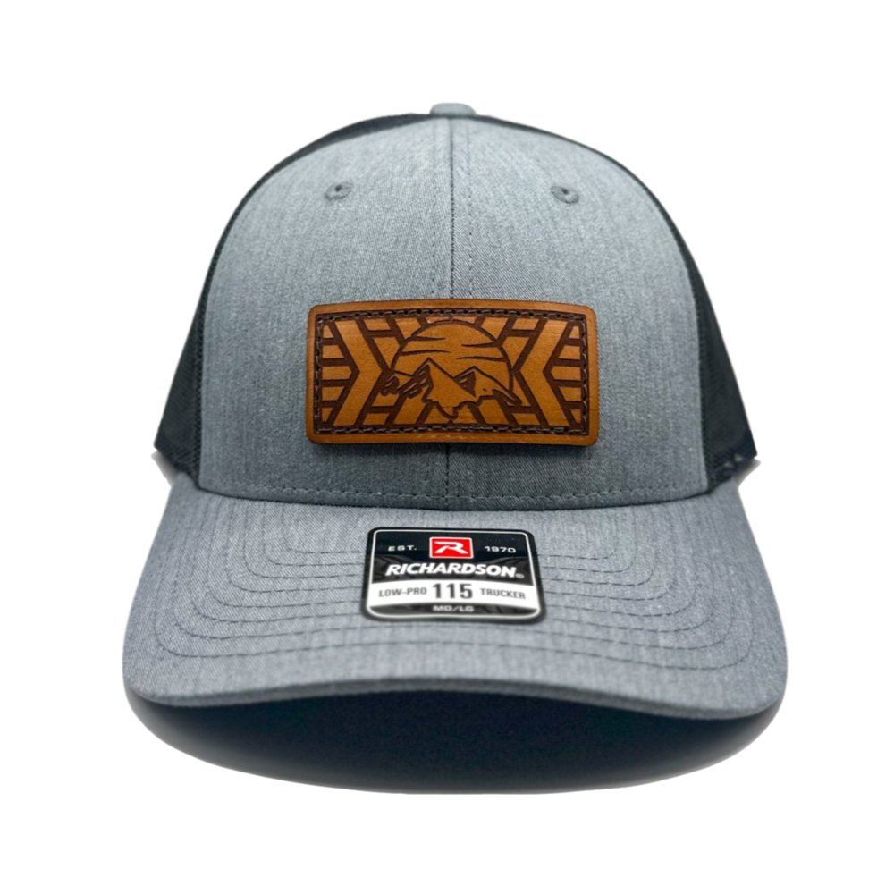 Front view of the Mosaic Mountain Leather Patch Hat by Outer Wings in heather grey/black, featuring a unique leather patch on a low profile Richardson 115 hat. This custom leather patch hat is perfect as an outdoors hat, combining a sleek silhouette with a laser-engraved mountain and sunset design. The adjustable SnapBack closure ensures comfort and style.