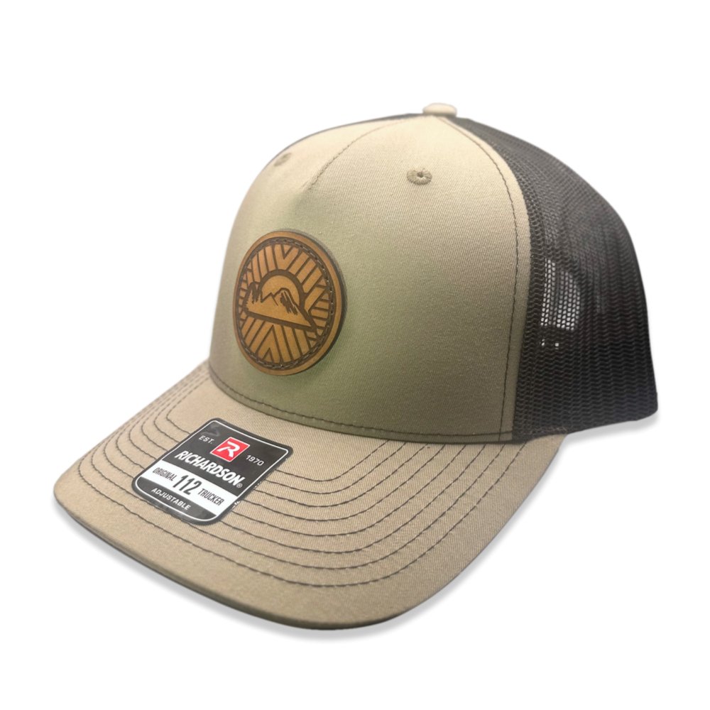 Side view of the Mosaic Sunset Leather Patch Hat by Outer Wings in khaki/coffee, showing the mid-profile structure of the Richardson 112FP. The detailed leather patch with a Mosaic Sunset engraving adds a rugged, artistic flair to this custom leather patch hat, perfect for outdoor enthusiasts. The mesh back and adjustable Snap-Back ensure a comfortable and secure fit.