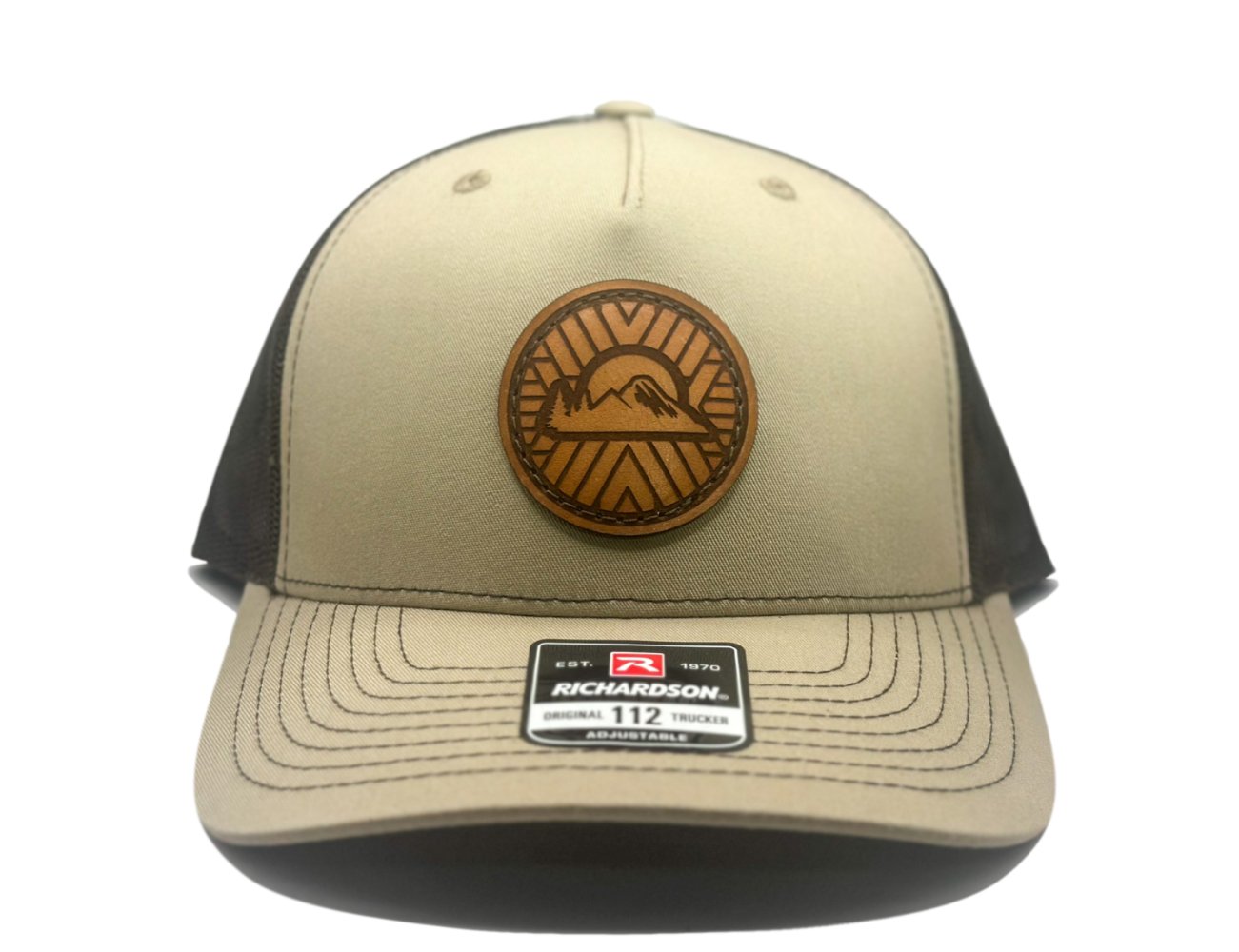 Front view of the Mosaic Sunset Leather Patch Hat by Outer Wings in khaki/coffee, featuring a laser-engraved full-grain leather patch on the Richardson 112FP trucker hat. The custom leather patch showcases the Mosaic Sunset design, hand-sewn for durability. This hat combines a seamless face with a breathable mesh back and adjustable Snap-Back closure, offering a stylish outdoors hat for any adventure.