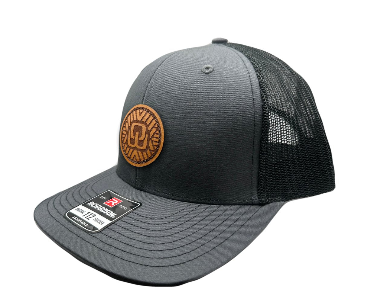 Side view of the Mosaic Wings Leather Patch Hat by Outer Wings in charcoal/black, showcasing the structured mid-profile design of the Richardson 112 hat. The detailed leather patch with the Mosaic Wings engraving adds a touch of style to this custom leather patch hat, perfect for those seeking a high-quality outdoors hat. The mesh back and adjustable SnapBack closure enhance comfort and fit.