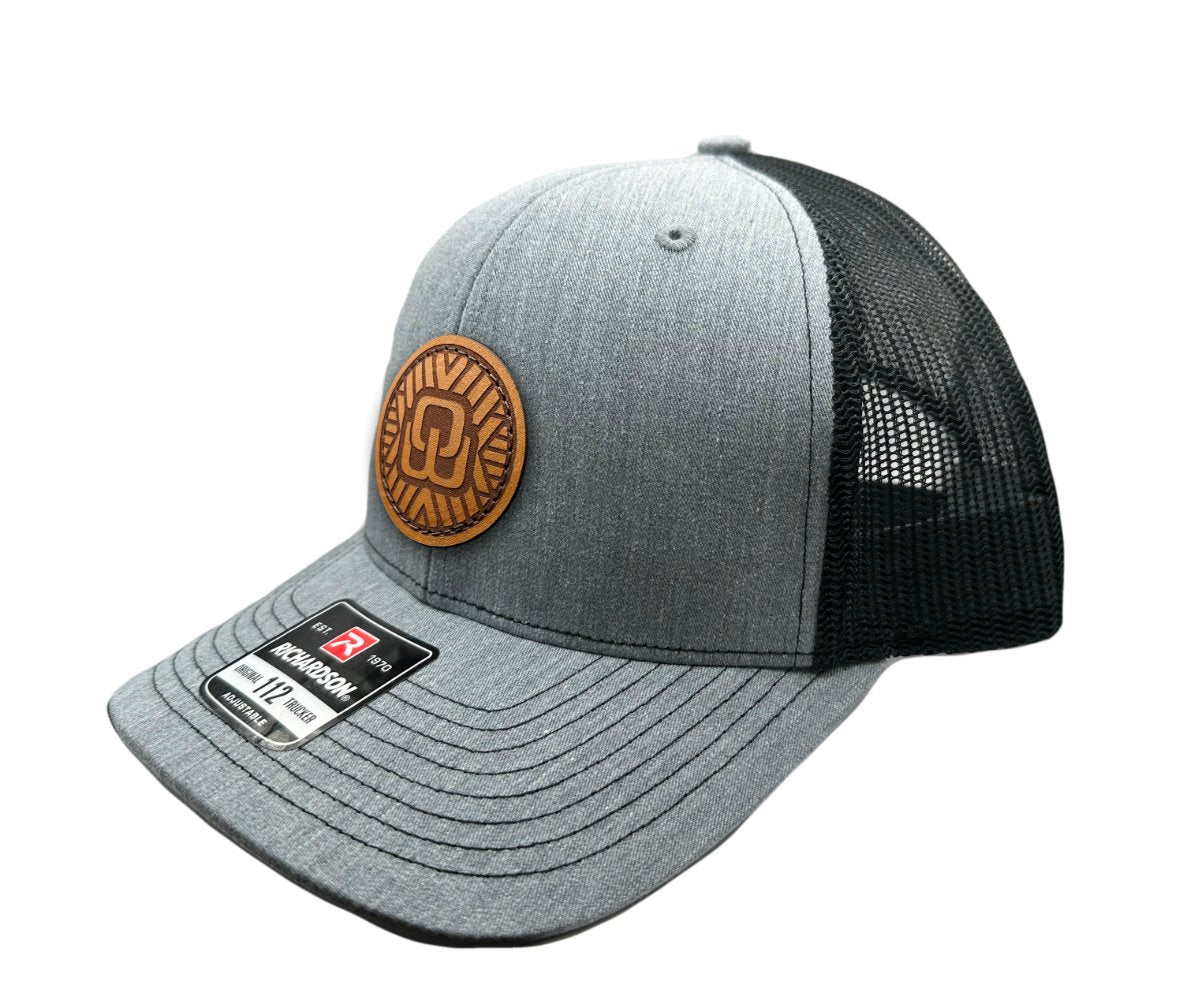 Side view of the Mosaic Wings Leather Patch Hat by Outer Wings in heather grey/black, highlighting the mid-profile structure of the Richardson 112. The leather patch with the Mosaic Wings design adds a unique element to this custom leather patch hat, ideal for both casual wear and outdoor adventures. The breathable mesh back and adjustable SnapBack provide comfort and a secure fit.