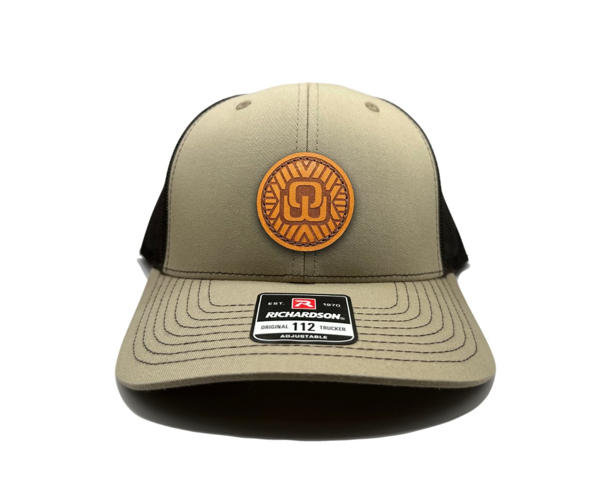 Front view of the Mosaic Wings Leather Patch Hat by Outer Wings in khaki/brown, crafted on the Richardson 112 trucker hat. This custom leather patch hat features a square leather patch with a laser-engraved Mosaic Wings design, sewn onto the structured mid-profile hat. The breathable mesh back and adjustable SnapBack closure ensure a secure and comfortable fit for outdoor activities.