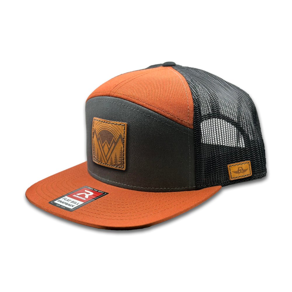 Side view of the Richardson 168 Flat-Bill Trucker Hat in charcoal/burnt orange/black, showing the structured high-profile style and breathable mesh back. The flat bill and adjustable SnapBack closure make it perfect for those seeking a distinctive, versatile outdoor hat.