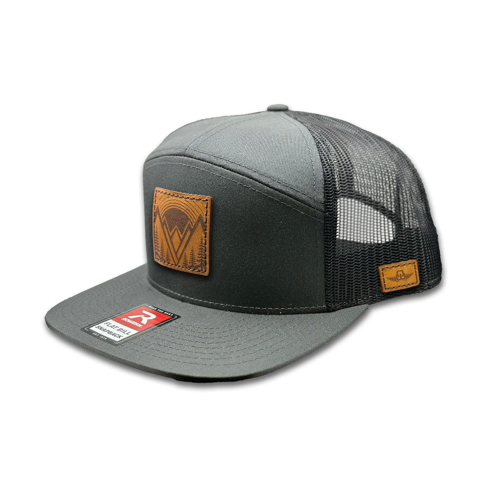 Side view of the Richardson 168 Flat Bill Trucker Hat in charcoal/black, featuring a structured high-profile design and a breathable mesh back. The flat bill and adjustable SnapBack closure provide comfort and style, ideal for those looking for a versatile outdoor hat.