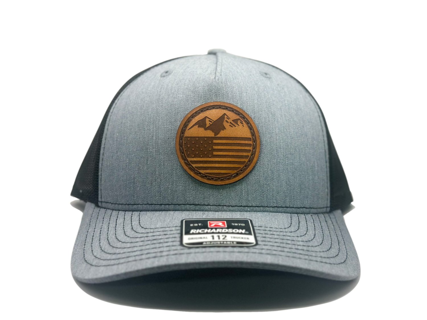 Front view of the Mountain Flag leather patch hat on Richardson 112FP in Heather/Black, featuring a five-panel, mid-profile design with a real leather patch showcasing mountains and the American flag. Ideal for outdoor enthusiasts and patriots