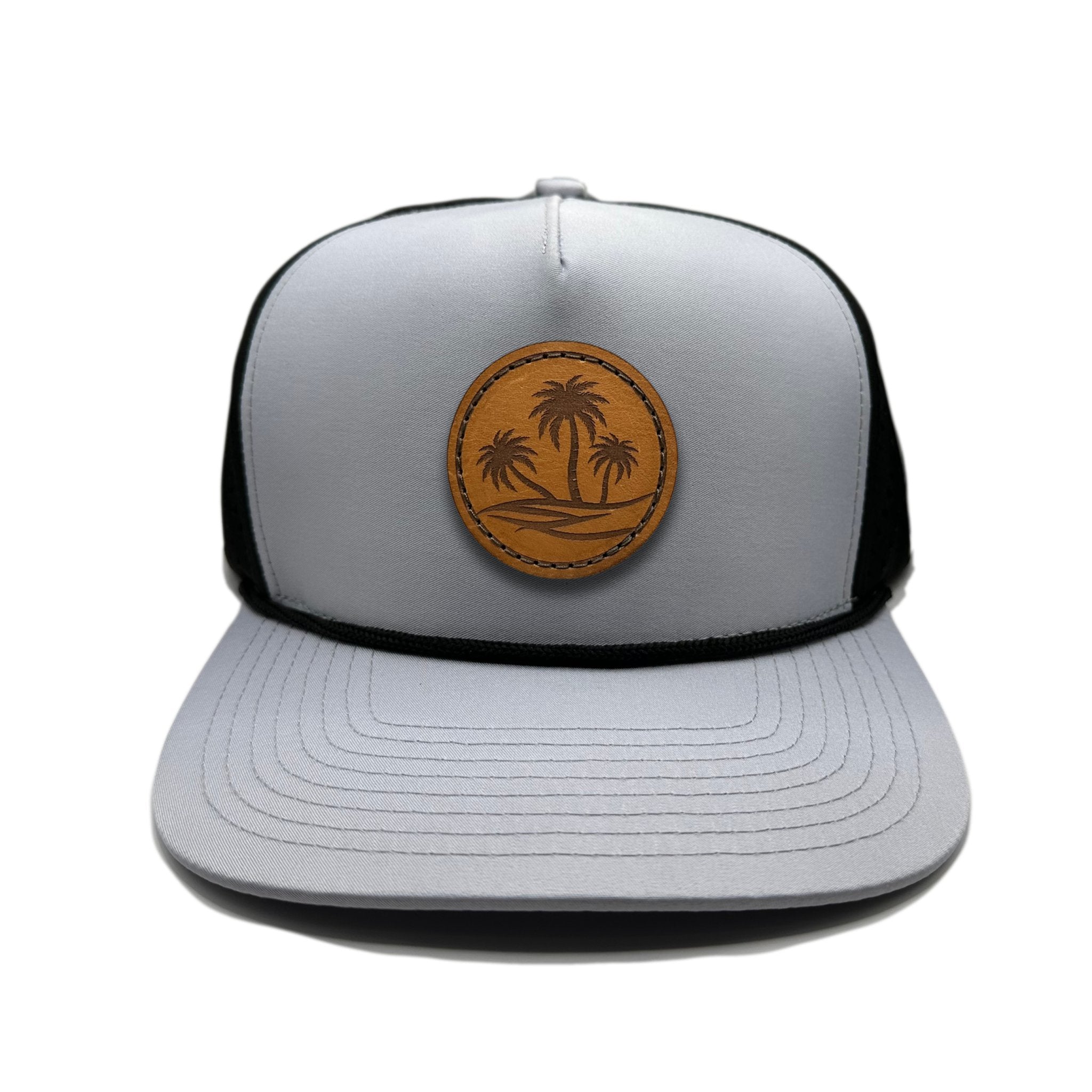 Front view of the Oasis Hat by Outer Wings in grey/black, featuring a high-profile Outer Wings 970 rope trucker hat with a round palm tree patch. Ideal for beach lovers and outdoor adventurers alike.