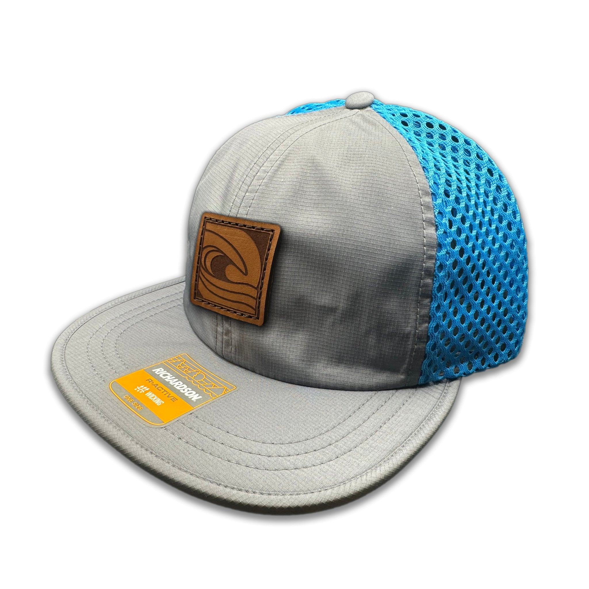 Side view of the Ocean Swell Hat by Outer Wings in Charcoal/Cyan, highlighting the wide-set mesh back, adjustable webbing backstrap, and flex packable visor. A functional and stylish performance hat for all-day comfort.