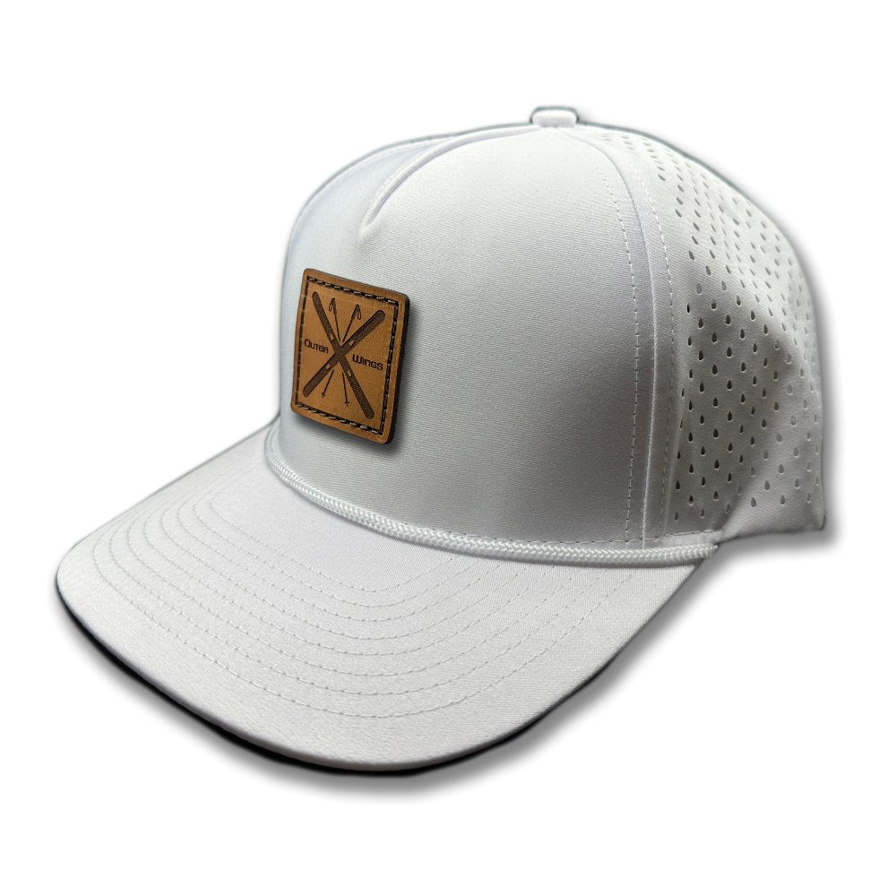 Side view of the Alpine Wings Hat by Outer Wings in white, highlighting the structured profile, classic rope detail, and distinctive square patch with crossed skis and 'Outer Wings.' The high-profile hat is made from durable, water-resistant fabric with an adjustable snapback closure.