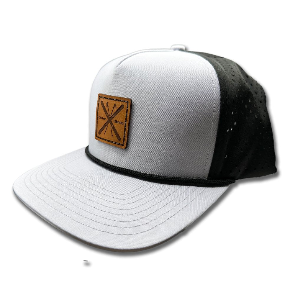 Side view of the Alpine Wings Hat by Outer Wings in grey/black, highlighting the structured profile, classic rope detail, and the square patch with crossed skis and 'Outer Wings.' The hat's water-resistant fabric and adjustable snapback closure make it perfect for outdoor enthusiasts.