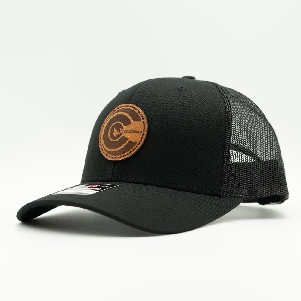 Side view of black-on-black Richardson 112 trucker hat with round leather Colorado flag patch, mesh back and curved bill.

Color: Solid Black