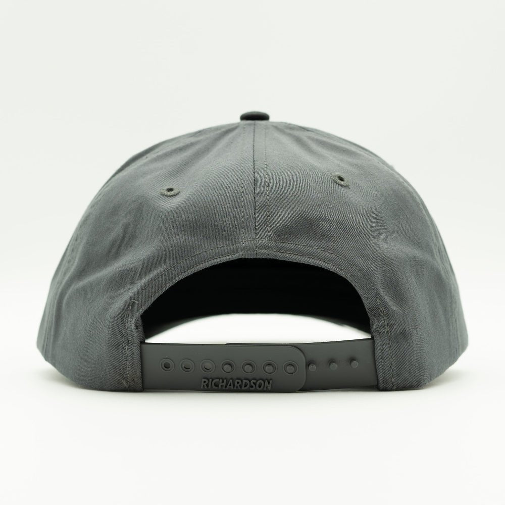 Back view of black/charcoal Richardson 312 hat showing snapback adjustment and full-fabric back panels