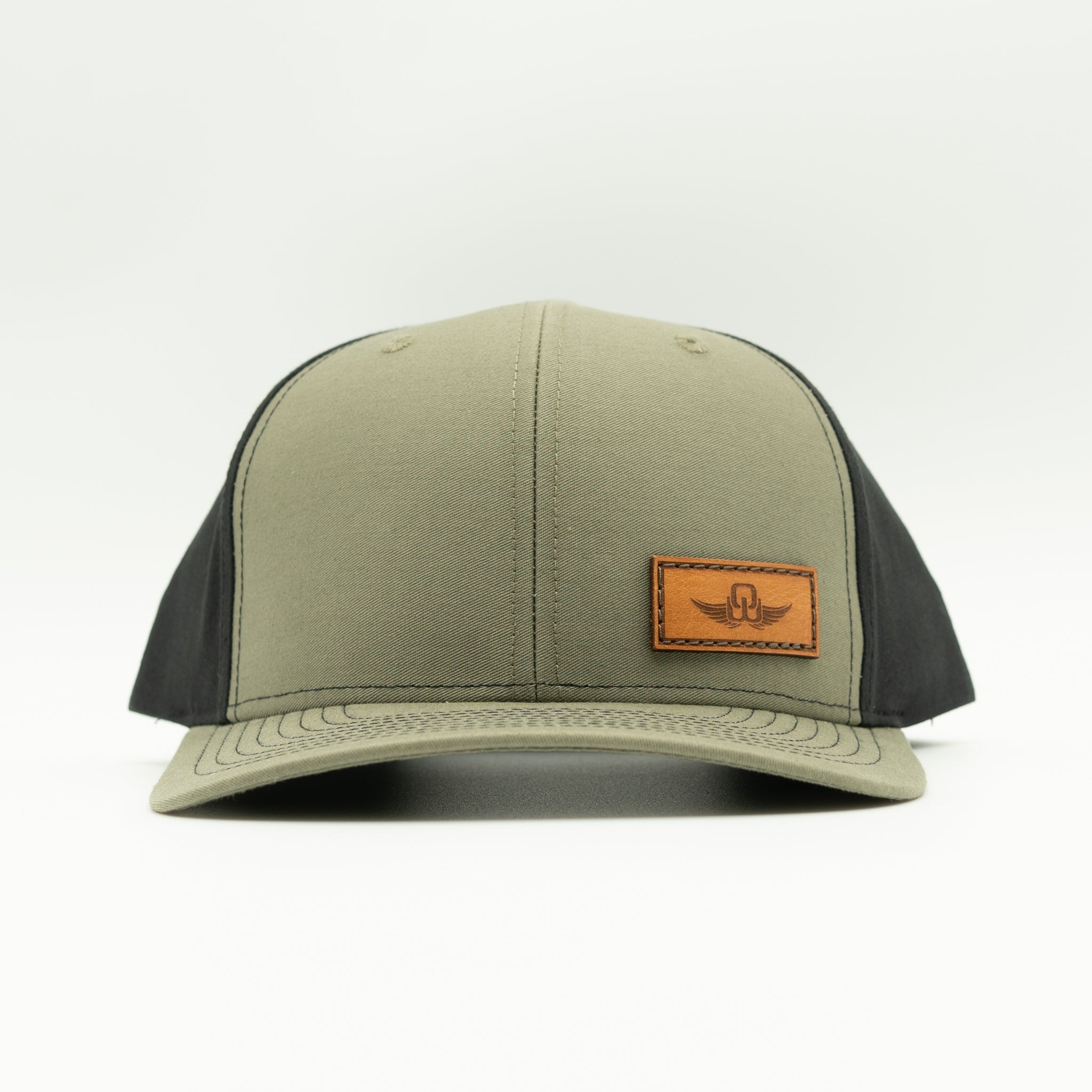 Front view of loden/black Richardson 312 full-fabric hat with sewn real leather Spread Your Wings patch and curved bill
