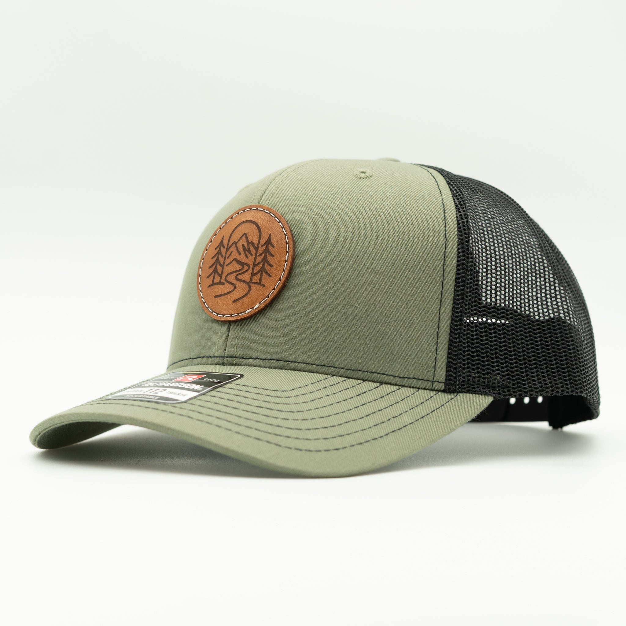 Side view of The Passage Richardson 112 loden and black leather patch mountain hat with mesh back and flat brim.