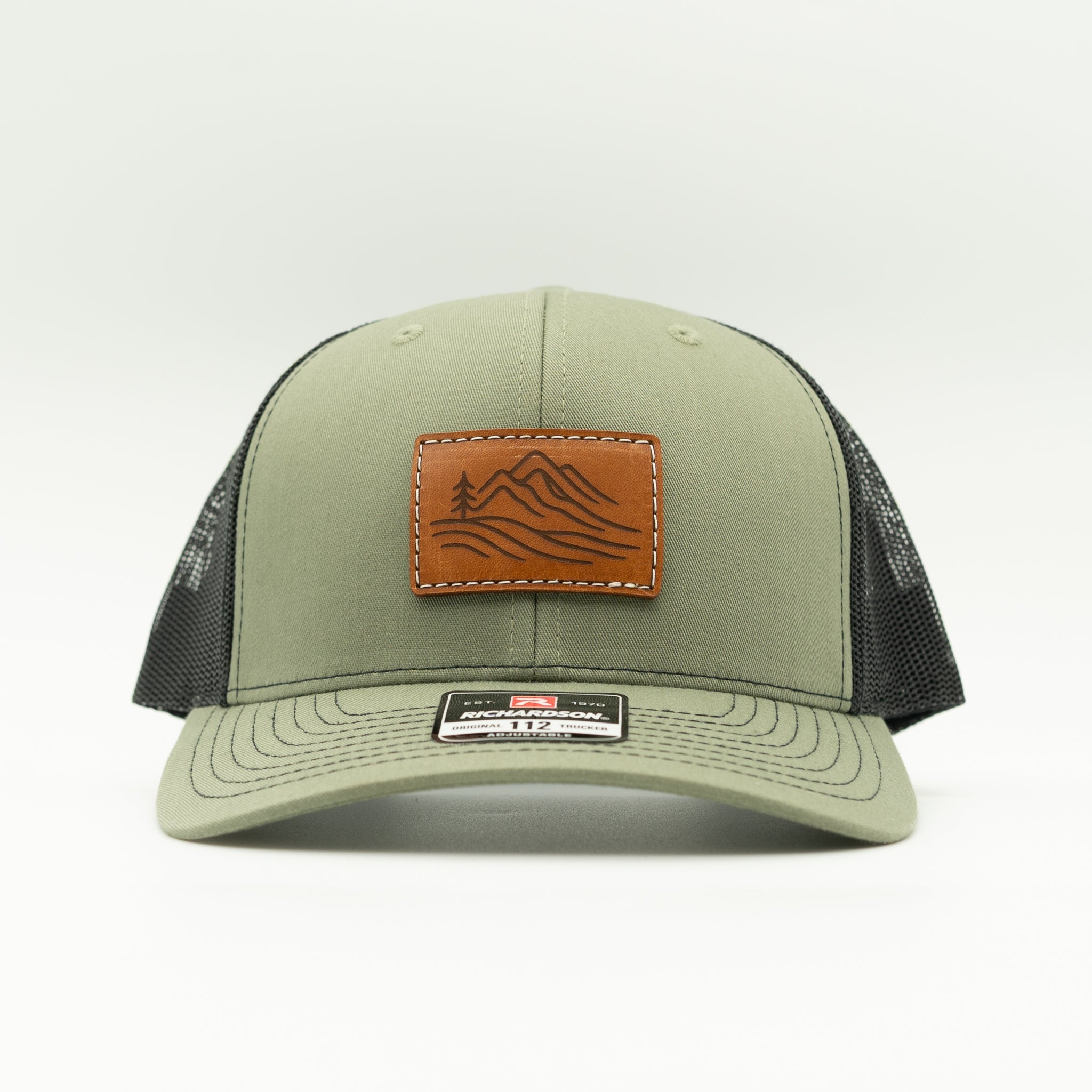 Front view of loden and black Richardson 112 Driftline hat featuring rectangular leather mountain range patch.

Color: Loden/Black