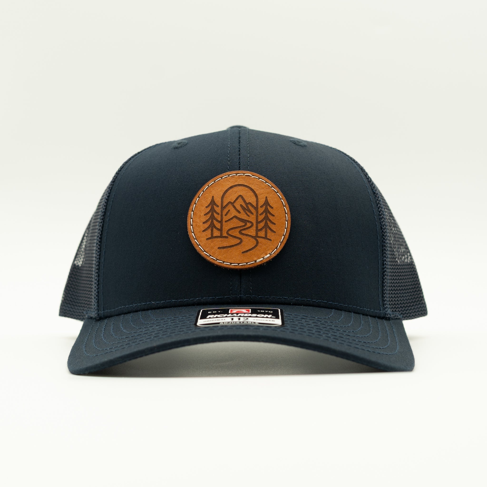 Front view of solid navy Richardson 112 The Passage hat with round veg tan leather mountain trail patch.