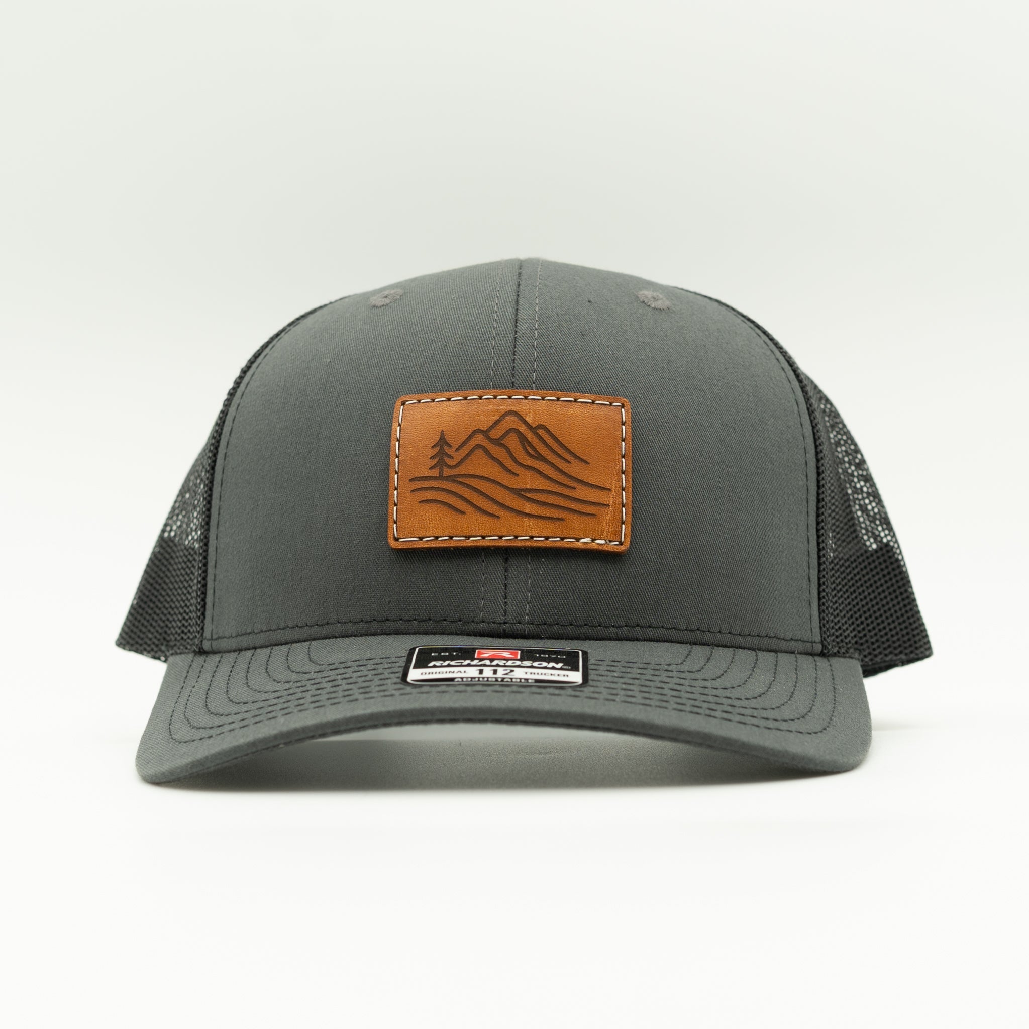 Front view of charcoal and black Richardson 112 Driftline hat featuring engraved leather mountain range patch

Color: Charcoal/Black